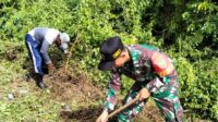 Babinsa Juru Seberang Ikuti Kerja Bakti Membersihkan Rumput dan Sampah di Bahu Jalan